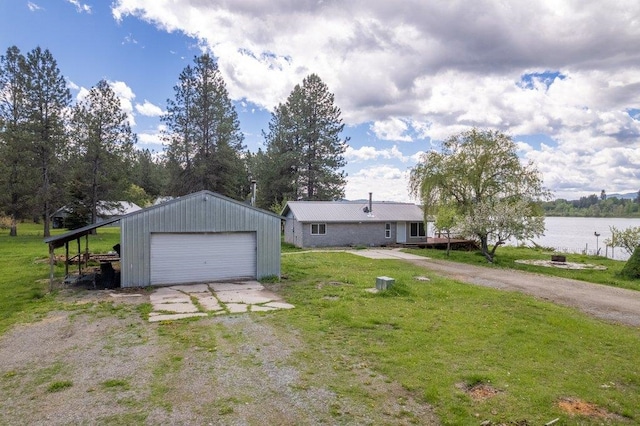 472 Snow Berry Ln, Usk, WA 99180 - view of front of property featuring a detached garage, a front yard, an outbuilding, and a water view