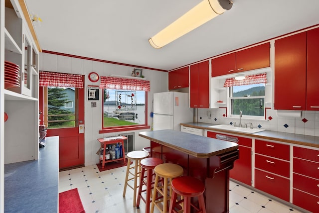 46273 Larson Beach Rd, Loon Lake, WA 99148 - kitchen with red cabinetry, light floors, white appliances, and a sink