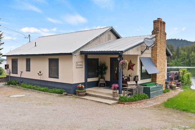 46273 Larson Beach Rd, Loon Lake, WA 99148 - view of front of home with a chimney, metal roof, and covered porch