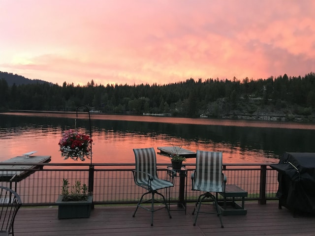 46273 Larson Beach Rd, Loon Lake, WA 99148 - deck at dusk featuring a wooded view and a water view
