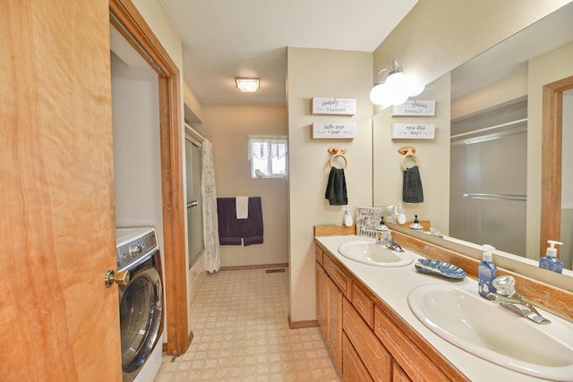 5024 E Ballard Rd, Colbert, WA 99005 - full bathroom with washer / dryer, tile patterned floors, double vanity, and bath / shower combo with glass door
