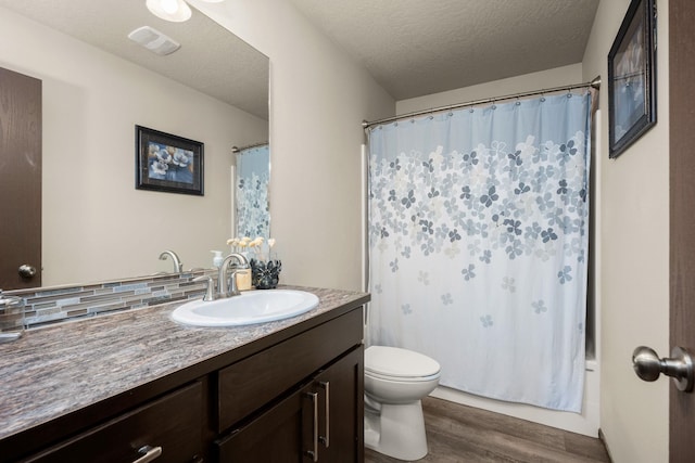 1516 E First Ct, Deer Park, WA 99006 - bathroom with vanity, wood finished floors, toilet, and a textured ceiling