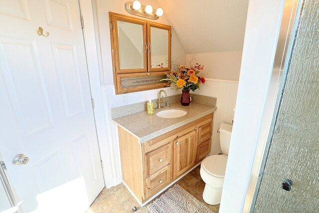 1327 N Howard St, Spokane, WA 99201 - bathroom with toilet, lofted ceiling, vanity, and a wainscoted wall