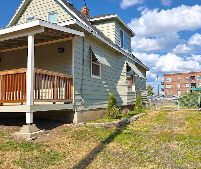 1327 N Howard St, Spokane, WA 99201 - view of side of home with a chimney, a gate, and a deck