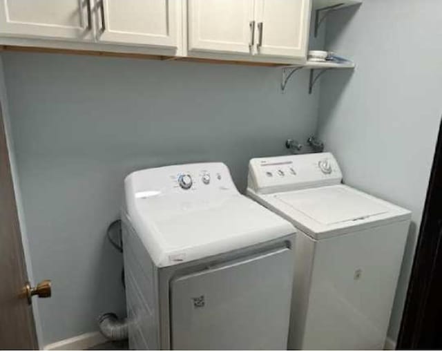 1002 W 7th Ave Unit 203, Spokane, WA 99204 - washroom with cabinet space, washer and dryer, and baseboards