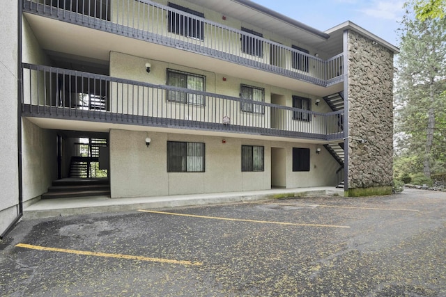 1002 W 7th Ave Unit 203, Spokane, WA 99204 - view of property featuring stairway and uncovered parking
