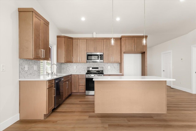 4229 W Tolliver Ct, Spokane, WA 99208 - kitchen with appliances with stainless steel finishes, a kitchen island, baseboards, backsplash, and a sink