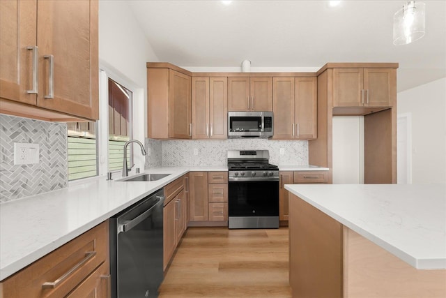 4229 W Tolliver Ct, Spokane, WA 99208 - kitchen featuring stainless steel appliances, a sink, light wood-type flooring, and backsplash