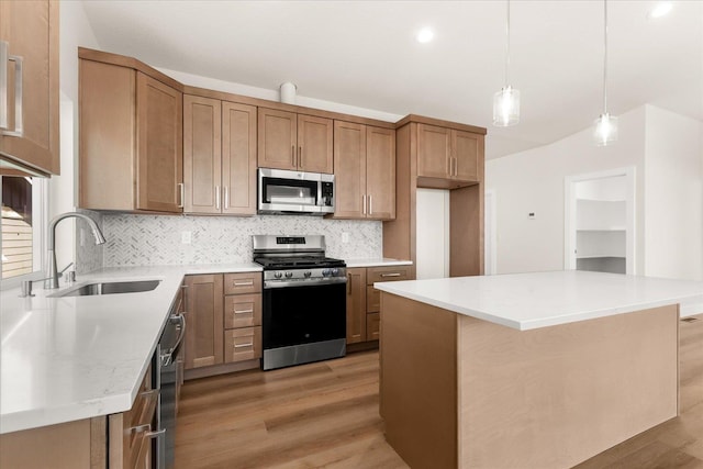 4229 W Tolliver Ct, Spokane, WA 99208 - kitchen featuring appliances with stainless steel finishes, a sink, light wood-type flooring, decorative backsplash, and brown cabinetry