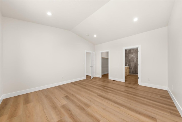 4229 W Tolliver Ct, Spokane, WA 99208 - unfurnished bedroom featuring lofted ceiling, a walk in closet, baseboards, ensuite bath, and light wood finished floors