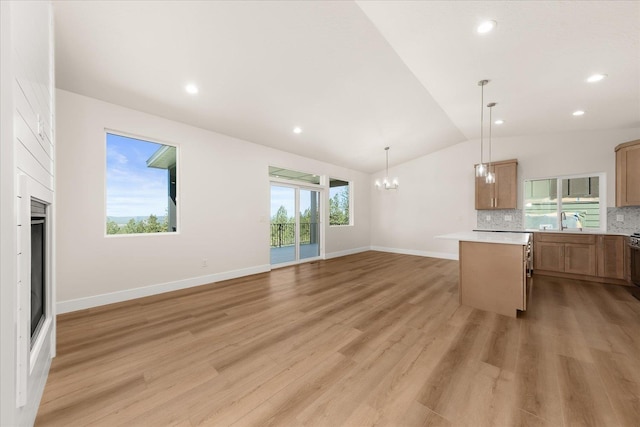 4229 W Tolliver Ct, Spokane, WA 99208 - unfurnished living room with lofted ceiling, a sink, a chandelier, light wood-style flooring, and baseboards