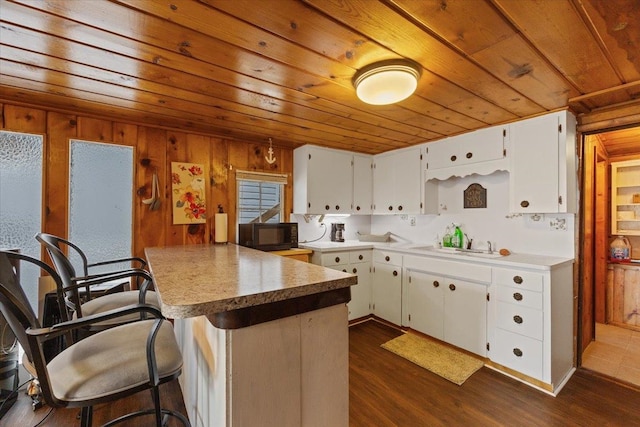 12931 N N Park St, Newman Lake, WA 99006 - kitchen featuring wood ceiling, white cabinets, a peninsula, dark wood finished floors, and a breakfast bar