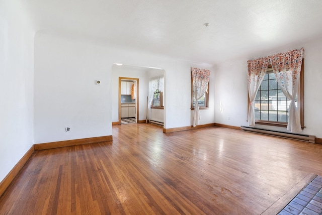 106 E 29th Avenue Corner Of 29Th & Tekoa - Entry & Garage On Tekoa, Spokane, WA 99203 - empty room with a baseboard heating unit, arched walkways, wood finished floors, and baseboards