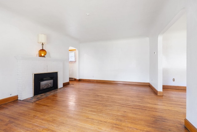 106 E 29th Avenue Corner Of 29Th & Tekoa - Entry & Garage On Tekoa, Spokane, WA 99203 - unfurnished living room with arched walkways, light wood-style flooring, and a fireplace