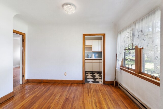 106 E 29th Avenue Corner Of 29Th & Tekoa - Entry & Garage On Tekoa, Spokane, WA 99203 - empty room with a baseboard heating unit, baseboards, and wood finished floors