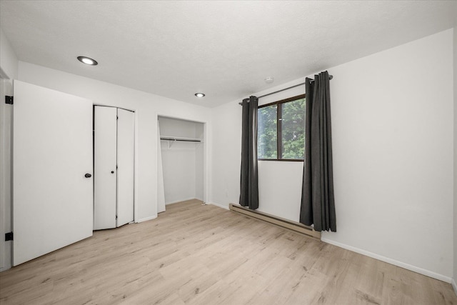 20716 E Gilbert Rd, Otis Orchards, WA 99027 - unfurnished bedroom featuring light wood finished floors, recessed lighting, multiple closets, baseboards, and a textured ceiling