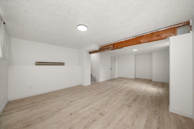 20716 E Gilbert Rd, Otis Orchards, WA 99027 - finished below grade area featuring light wood-style flooring, stairway, baseboards, and a textured ceiling