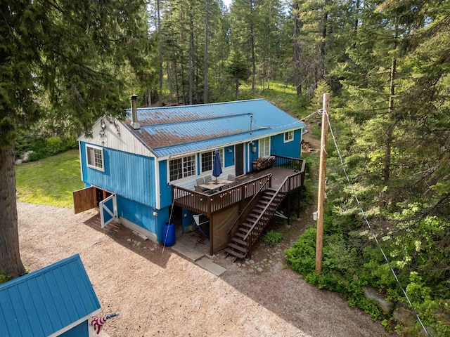 8431 Fertile Valley Rd, Newport, WA 99156 - view of front of house with stairs, metal roof, a wooden deck, and a forest view
