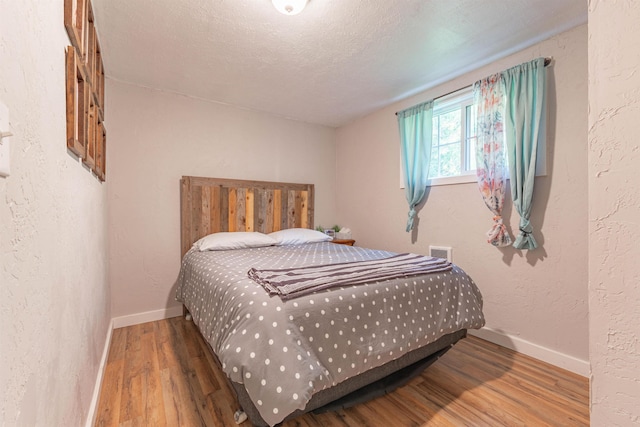 8431 Fertile Valley Rd, Newport, WA 99156 - bedroom with wood finished floors, baseboards, and a textured wall
