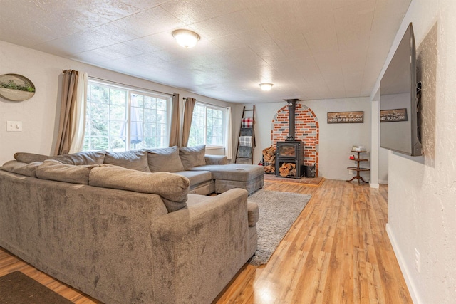 8431 Fertile Valley Rd, Newport, WA 99156 - living area featuring light wood-type flooring, a wood stove, and a textured wall