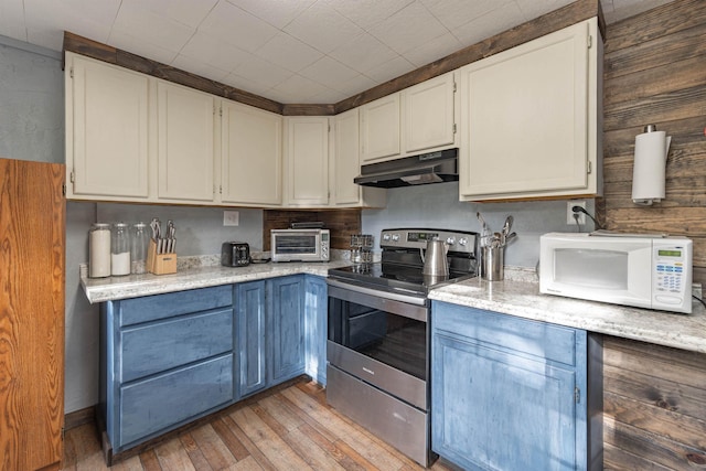 8431 Fertile Valley Rd, Newport, WA 99156 - kitchen featuring electric range, white microwave, under cabinet range hood, light wood-type flooring, and white cabinets