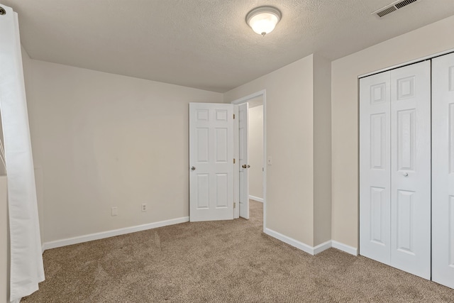 4022 E 25th Ave, Spokane, WA 99223 - unfurnished bedroom with carpet floors, a textured ceiling, a closet, and baseboards