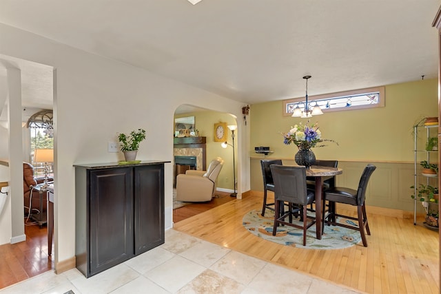 4022 E 25th Ave, Spokane, WA 99223 - dining area featuring arched walkways, light wood-style flooring, and a fireplace
