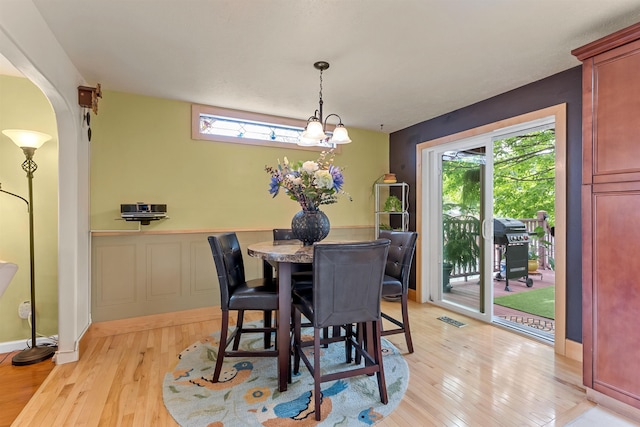 4022 E 25th Ave, Spokane, WA 99223 - dining area with light wood-style flooring, plenty of natural light, a wainscoted wall, and arched walkways