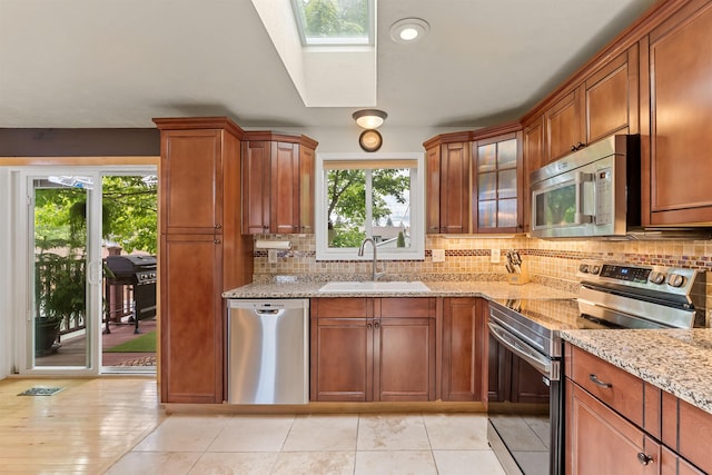 4022 E 25th Ave, Spokane, WA 99223 - kitchen with appliances with stainless steel finishes, a sink, decorative backsplash, and light stone counters