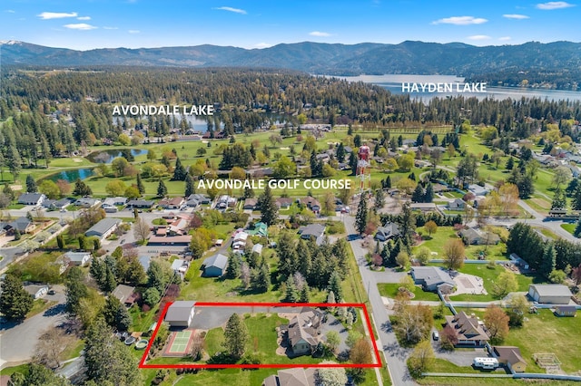 1467 E Lacey Ave, Hayden, ID 83835 - aerial overview of property's location featuring a water and mountain view, property parcel outlined, and a heavily wooded area