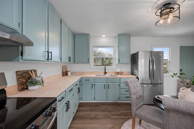 614 S Lawson St, Airway Heights, WA 99001 - kitchen with a sink, stainless steel appliances, under cabinet range hood, dark wood-style floors, and blue cabinetry