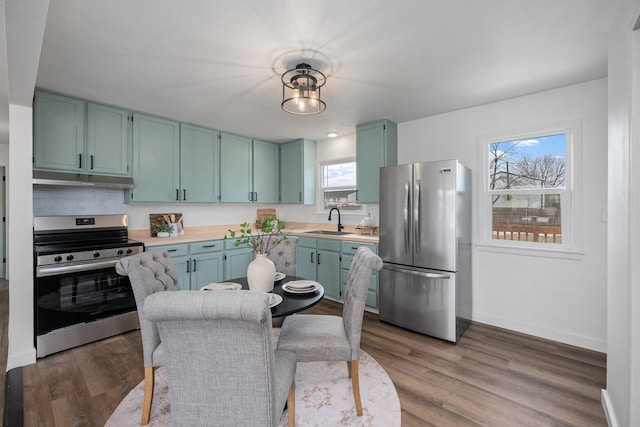 614 S Lawson St, Airway Heights, WA 99001 - kitchen with stainless steel appliances, a sink, light countertops, baseboards, and under cabinet range hood