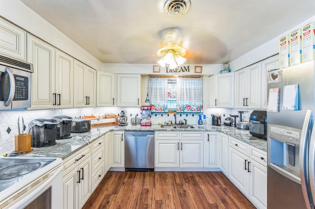 4004 W Taft Dr, Spokane, WA 99208 - kitchen with appliances with stainless steel finishes, a sink, tasteful backsplash, and dark wood-type flooring