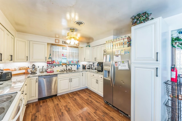 4004 W Taft Dr, Spokane, WA 99208 - kitchen with appliances with stainless steel finishes, a sink, dark wood-type flooring, light stone counters, and tasteful backsplash