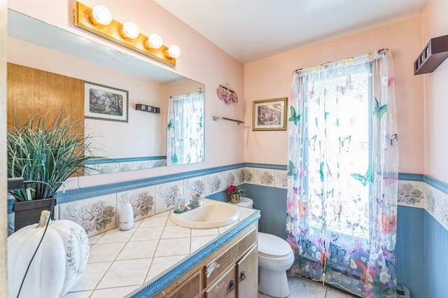 4004 W Taft Dr, Spokane, WA 99208 - bathroom featuring vanity, toilet, wainscoting, tile walls, and a shower with curtain
