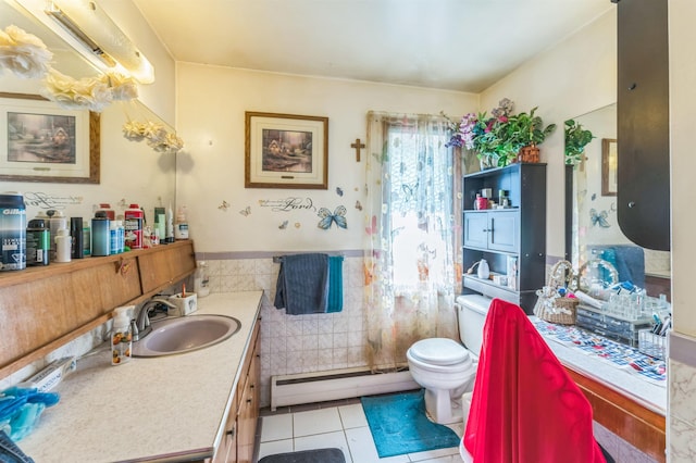 4004 W Taft Dr, Spokane, WA 99208 - full bathroom featuring a baseboard radiator, tile patterned flooring, toilet, vanity, and tile walls