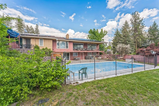 4004 W Taft Dr, Spokane, WA 99208 - rear view of house featuring a chimney, roof mounted solar panels, and a patio