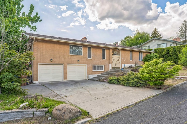 4004 W Taft Dr, Spokane, WA 99208 - bi-level home with a garage, driveway, brick siding, and a chimney
