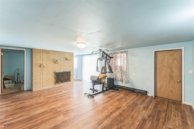 4004 W Taft Dr, Spokane, WA 99208 - exercise room featuring a fireplace, wood finished floors, and baseboards