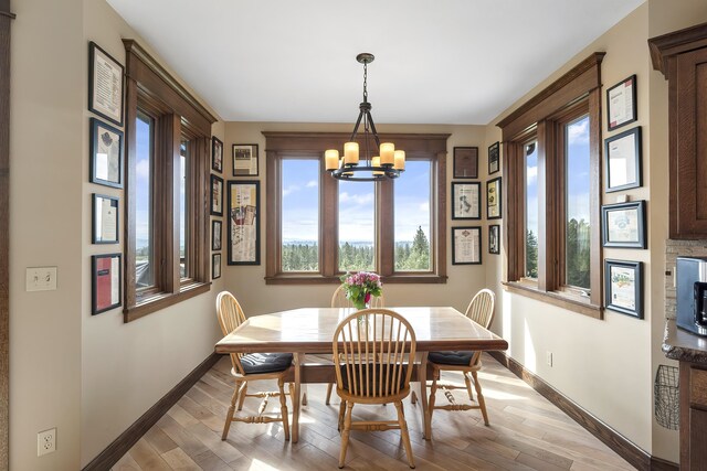 16510 N Brannon Ln, Spokane, WA 99208 - dining space with a chandelier, baseboards, and light wood-style floors