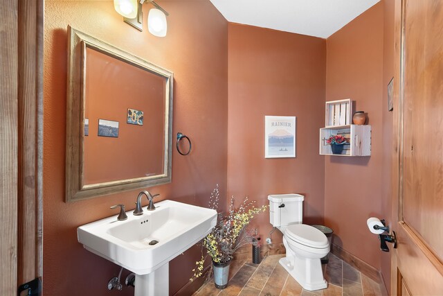16510 N Brannon Ln, Spokane, WA 99208 - half bathroom with toilet, a sink, stone finish flooring, and baseboards