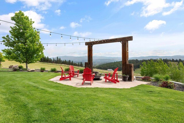 16510 N Brannon Ln, Spokane, WA 99208 - view of grassy yard featuring an outdoor fire pit, a patio area, and a mountain view