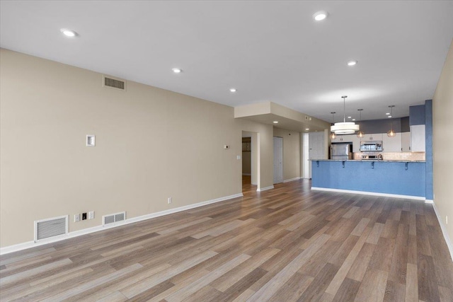 700 W 7th Ave # 206, Spokane, WA 99204 - unfurnished living room with light wood-style floors, baseboards, and recessed lighting