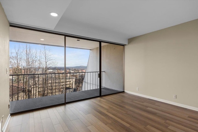 700 W 7th Ave # 206, Spokane, WA 99204 - spare room featuring wood finished floors, expansive windows, baseboards, and recessed lighting