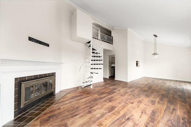 707 W 6th Ave Unit 41, Spokane, WA 99204 - unfurnished living room featuring ornamental molding, stairs, a fireplace, wood finished floors, and baseboards