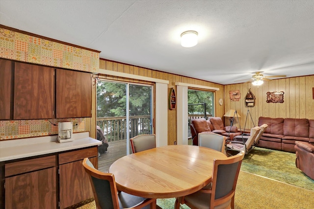 3970 Cedar Bay Rd, Loon Lake, WA 99148 - dining area with a ceiling fan, wooden walls, and a textured ceiling