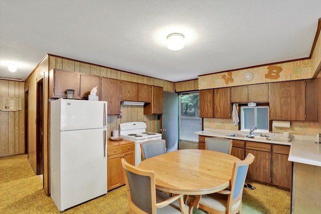 3970 Cedar Bay Rd, Loon Lake, WA 99148 - kitchen with white appliances, a sink, light countertops, brown cabinets, and wood walls