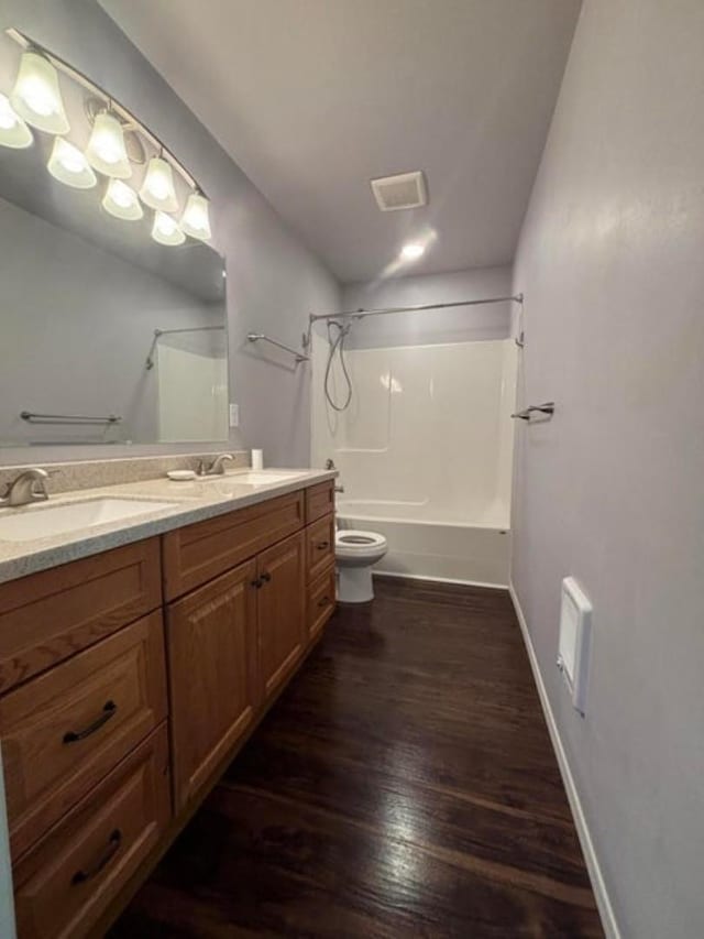 1108 Basin Rd, Colville, WA 99114 - full bath with toilet, double vanity, shower / bathtub combination, wood finished floors, and baseboards
