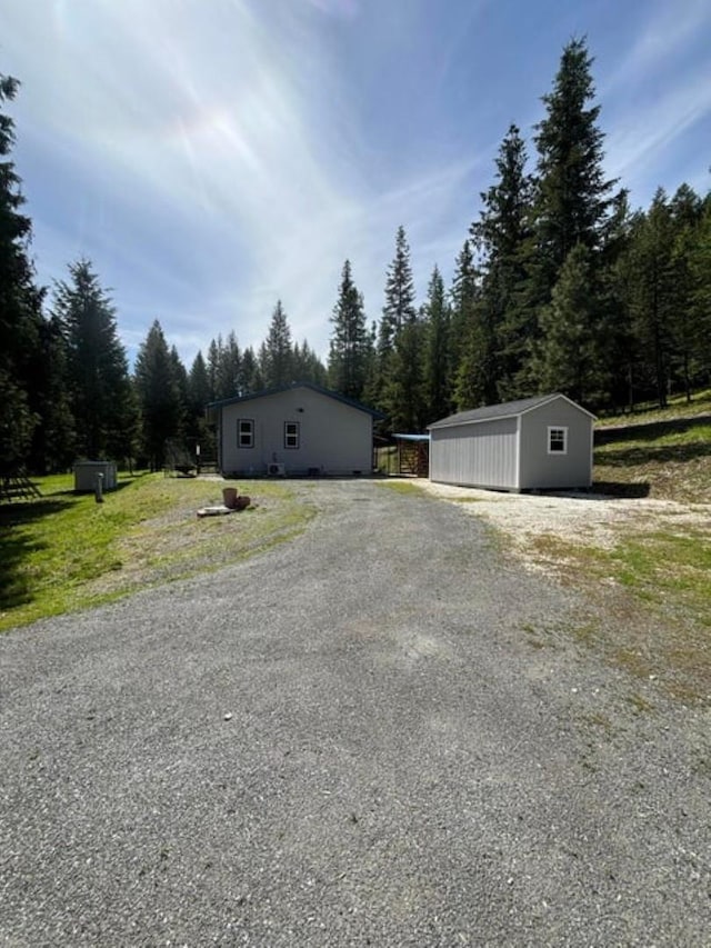 1108 Basin Rd, Colville, WA 99114 - view of side of home featuring an outbuilding and a wooded view