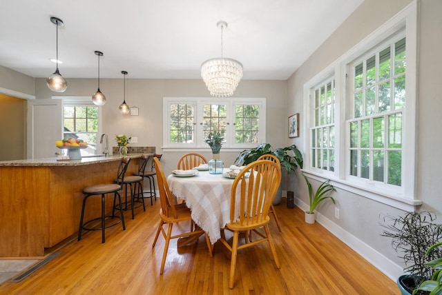 918 W 18th Ave, Spokane, WA 99203 - dining space with light wood-style flooring, a chandelier, and baseboards
